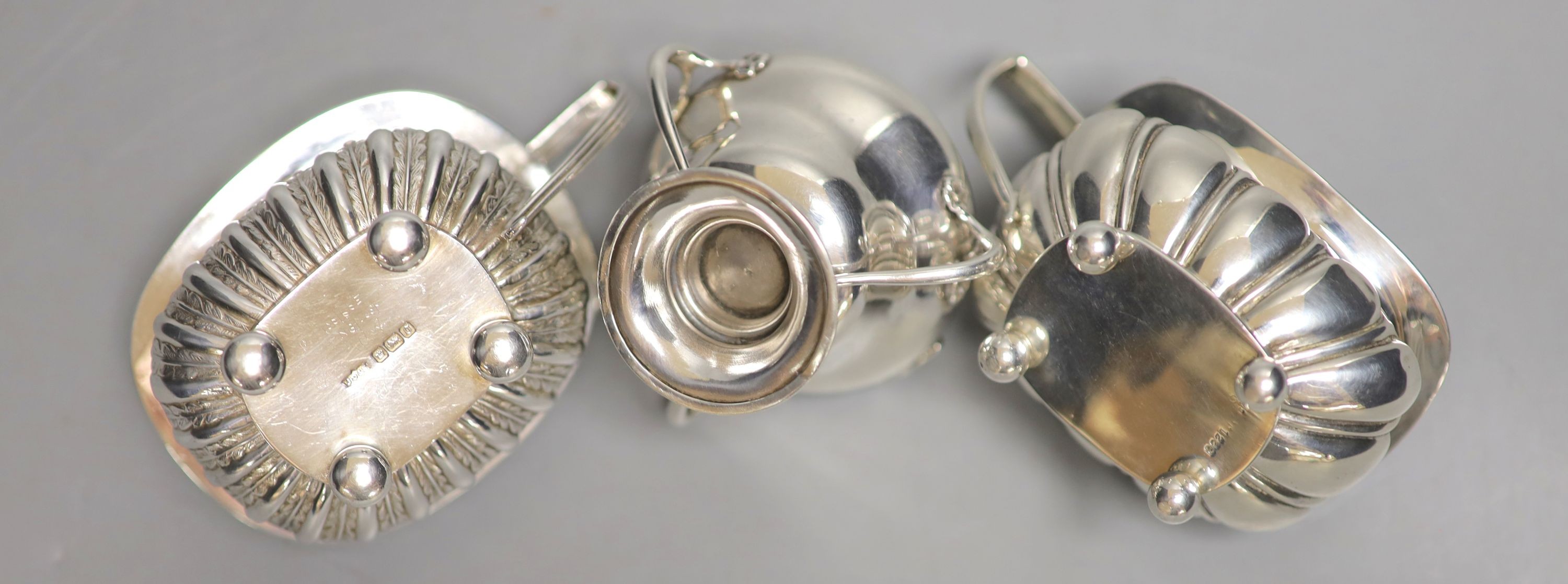 Three assorted 20th century silver mustard pots including Art Nouveau, Birmingham, 1909, tallest 6cm.